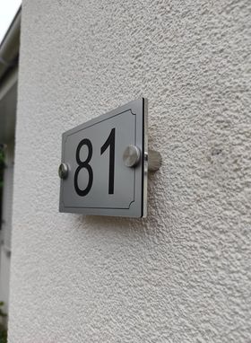 plaque numéro posée sur mur maison